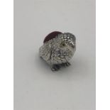 A silver pincushion in the form of a parrot