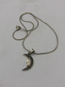 A silver pendant necklace in the form of a half moon set with Marcasite's