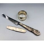 Three hallmarked silver items, a pen knife, napkin ring and a silver handled knife.