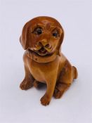 A Japanese Wooden Netsuke in the form of a dog signed to base