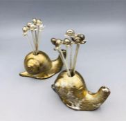 A pair of white metal French snails with snail forks.