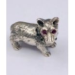 A silver figure of a dog with ruby eyes