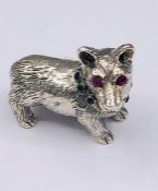 A silver figure of a dog with ruby eyes