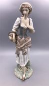 A Lladro figure of a lady holding a basket