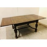 A Carved Oak dining table with detachable leaves.