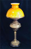 A Brass oil lamp with amber glass shade.