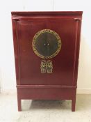 A Chinese Cabinet with red lacquer finish.