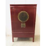 A Chinese Cabinet with red lacquer finish.