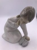 A Lladro figure Girl with a mothers shoe (13cm)