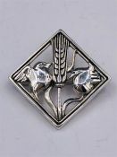 A silver Art Nouveau style brooch depicting a bird.