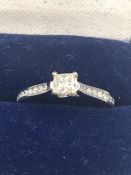 A Princess cut diamond ring, approx. 30pts with diamond shoulders on an 18ct gold setting.