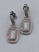 A pair of silver CZ and opal drop earrings