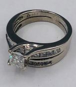 Two 14ct white gold rings one with princess cut central stone flanked by diamonds in the form of and