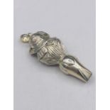 A silver plated whistle in the form of a child with a bonnet