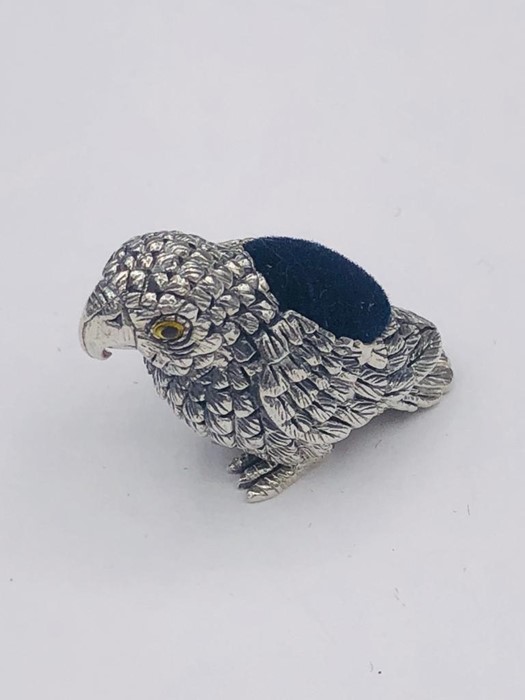 A silver parrot pincushion