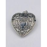 A Silver Heart shaped pocket with embossed decoration