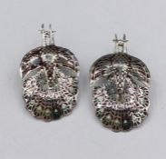 A pair of silver earrings in the form of peacocks