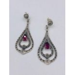 A pair of silver pear shaped earrings set with CZ's and Rubilite