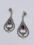 A pair of silver pear shaped earrings set with CZ's and Rubilite