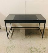 A Contemporary gun metal grey desk with two drawers, metal base and smoked glass top to one side and