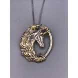 A silver unicorn pendant on a silver chain