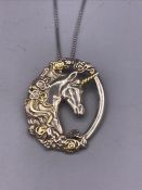 A silver unicorn pendant on a silver chain