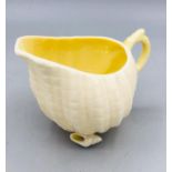 A Belleek shell themed creamer on shell feet