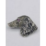A silver dog brooch set with Marcasite's and ruby eye