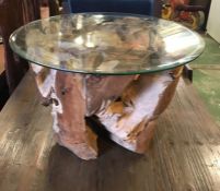 A Teak Tree Trunk Based coffee table with glass top.