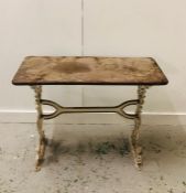 A Cast iron table, in white with wooden top.