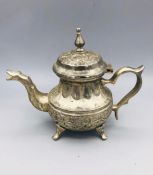 A white metal Persian teapot