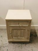 A Cream painted bedside cabinet with glass handles.