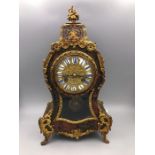 An 18th Century French Boulle Clock with enamel face and gilt decoration.