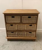 An Oak shelving unit with four rattan inserts.