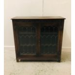 A Carved Oak glazed display cupboard