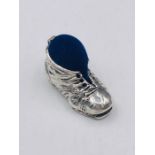 A silver boot shaped pincushion