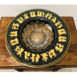 A large encased crystal bowl in green with classical figures in gold dancing.