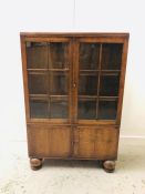 A Glazed oak cupboard on large bun feet.