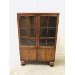 A Glazed oak cupboard on large bun feet.