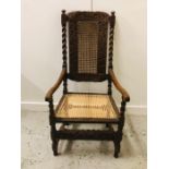 A High Back Walnut carver chair with caned seat and scrolled arms.