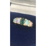 An Emerald and opal ring with diamond insets on an 18ct gold setting.