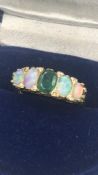 An Emerald and opal ring with diamond insets on an 18ct gold setting.