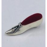 A silver pincushion in the form of a Victorian shoe