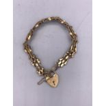 A 9ct yellow gold gate bracelet with heart shaped fastener. (7.7g)