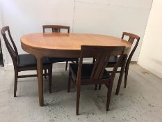 A Mid Century dining table with four leather seated chairs.
