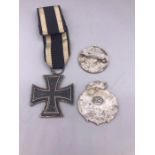 A WWI German Iron Cross and two Third Reich Badges as Found