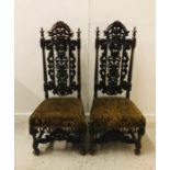 A Pair of Gothic style hymn back carved mahogany dining chairs with stretchers under