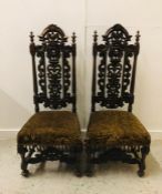 A Pair of Gothic style hymn back carved mahogany dining chairs with stretchers under