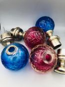 Two sets of cerise and aqua glass and white metal curtain pole finials
