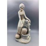 A Nao figure of a lady filling water jugs, in a matt finish.